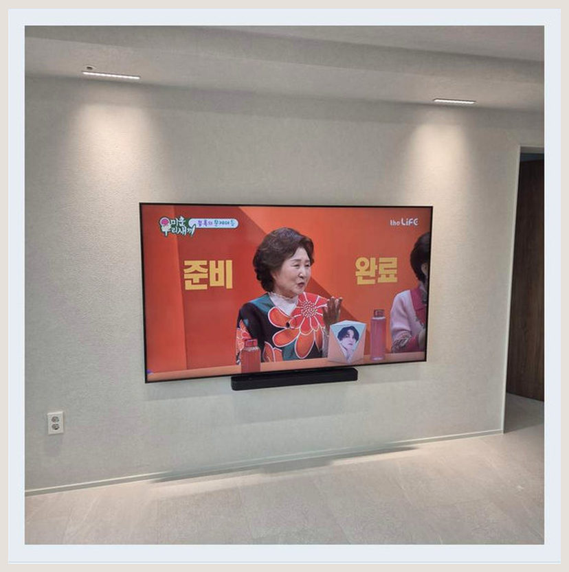 새집의 거실 크기에 맞추는 화면 높이에 필요한 벽체·브라켓 확인을 살펴볼 수 있는 벽걸이TV 설치 참고 사진 (해당 지역 시공 사례 아님)