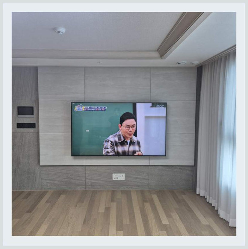 다른 거실로 옮긴 뒤 화면 반사 줄이기에 필요한 벽체·브라켓 확인을 살펴볼 수 있는 벽걸이TV 설치 참고 사진 (해당 지역 시공 사례 아님)