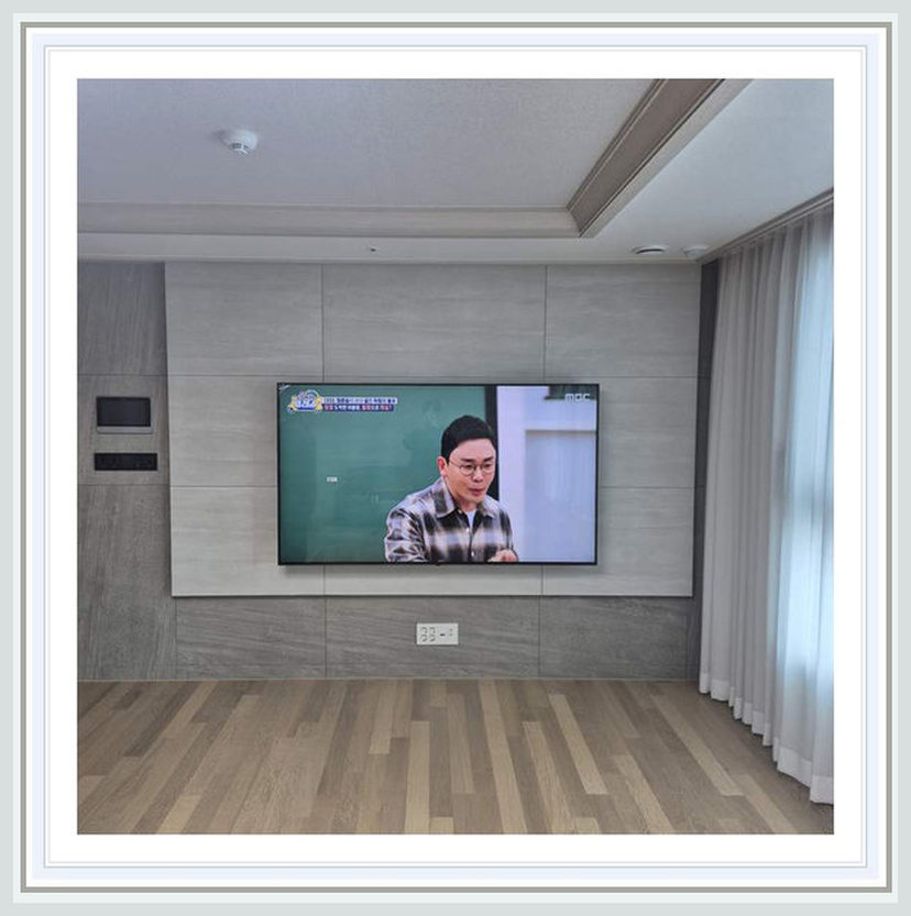 좁은 거실에 놓인 셋톱박스를 어디로 옮길까에 필요한 벽체·브라켓 확인을 살펴볼 수 있는 벽걸이TV 설치 참고 사진 (해당 지역 시공 사례 아님)